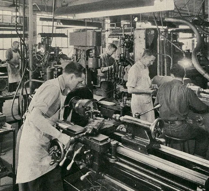 black and white photo of Andis employees working in factory line