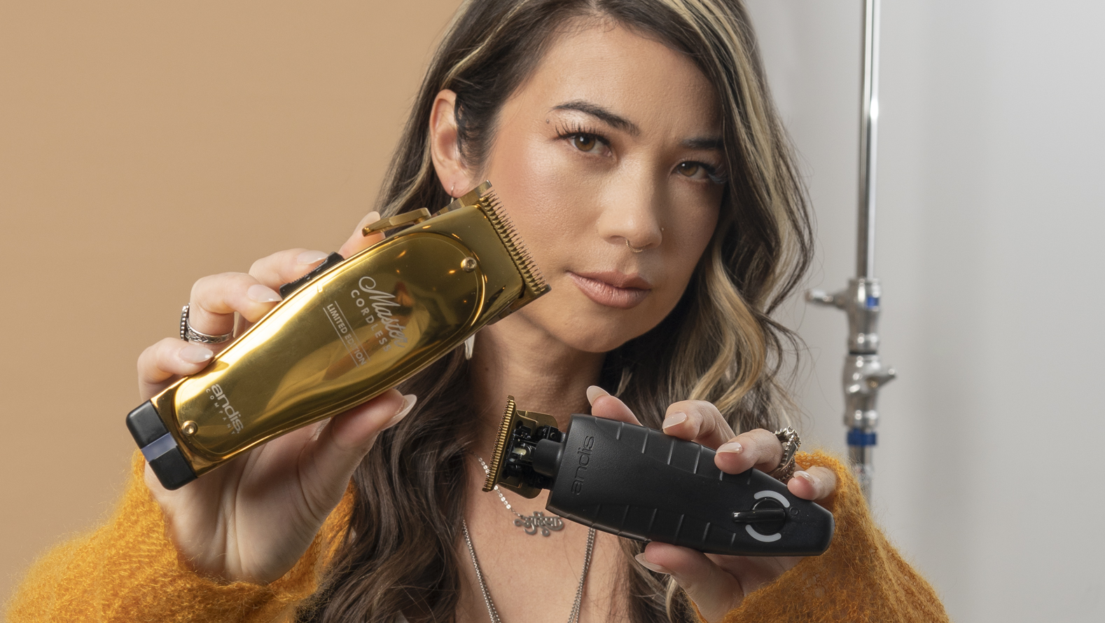 Vanessa Rene holding gold Master Cordless clipper and Cordless T-Outliner Trimmer